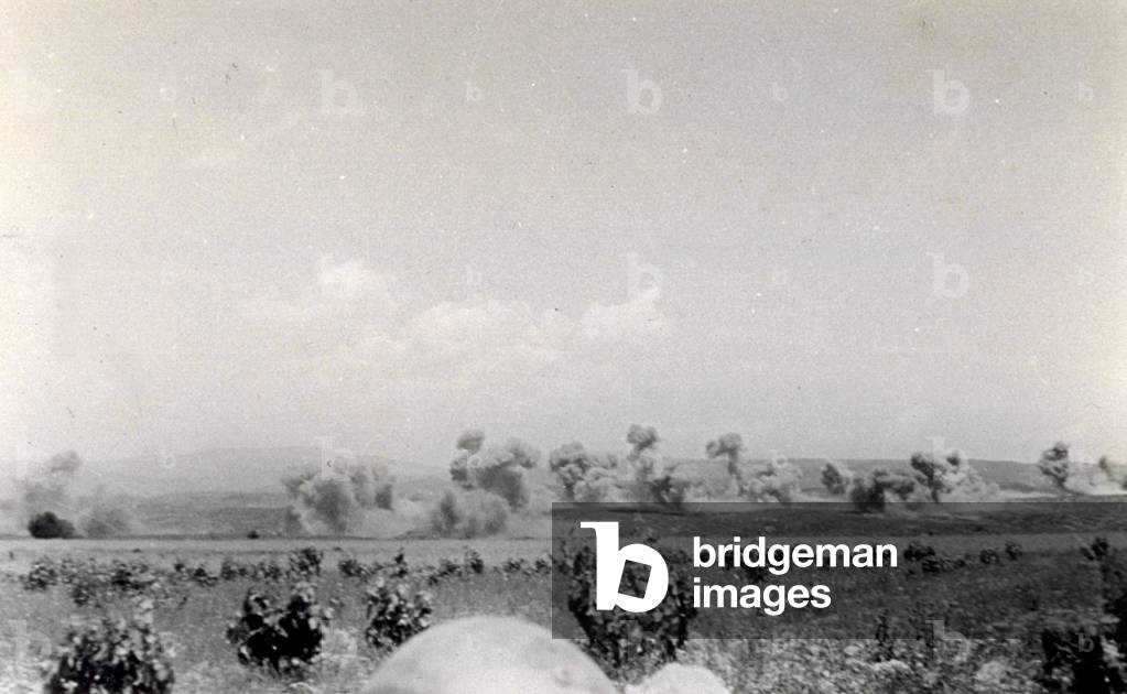 Battle field during the Spanish civil war, photographed on July 13, 1938, during the bombings by the Italian Aviation in the course of the action known as 'Del Levante'. Columns of smoke from the bombings rise up from the vast landscape covered with low vegetation (b/w photo)