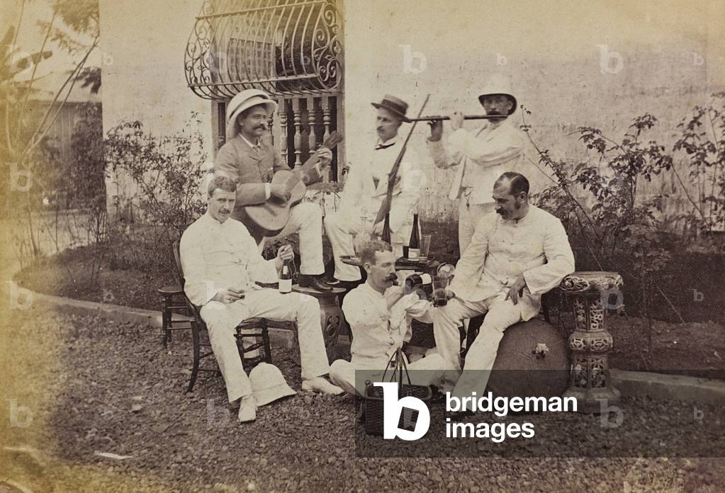 English group photographed in front of his villa in China while playing and drinking