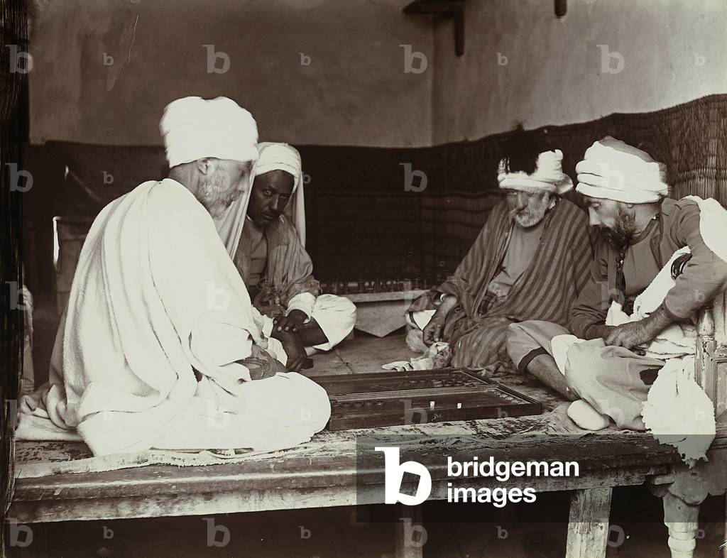 Four Turks seated on a wooden platform while playing a game, 1890 (print on double-weight paper)