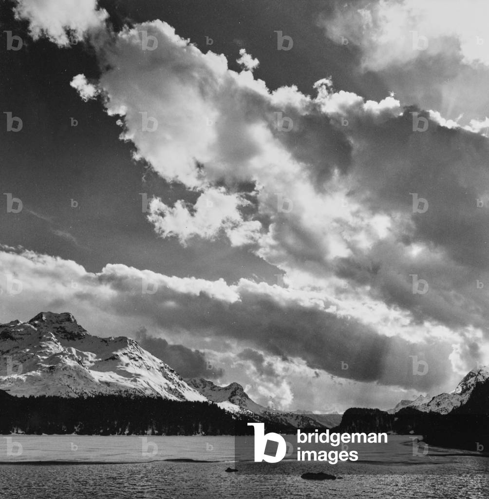 Clouds on a snowy mountain landscape with lake