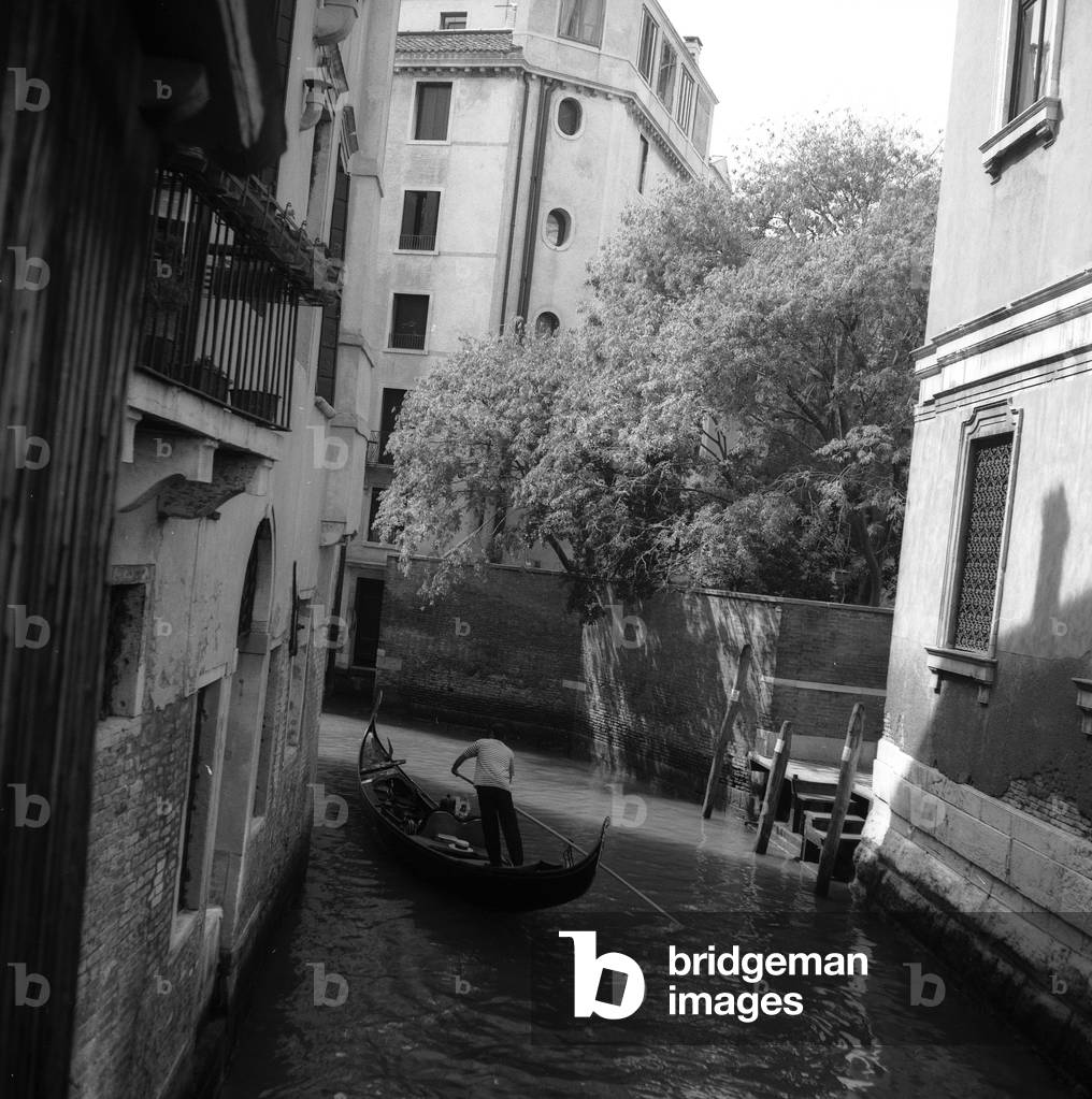 Passing of a gondola in a Venetian canal (b/w photo)