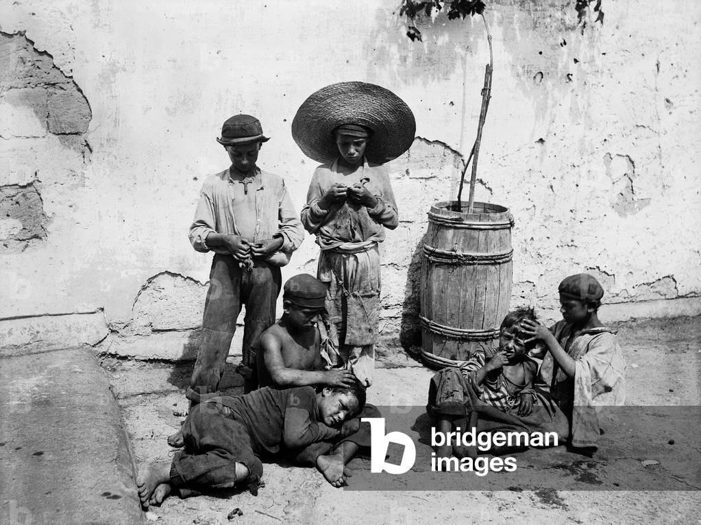 Children taking off lice from each other head in a street of Naples, in the past they were called 