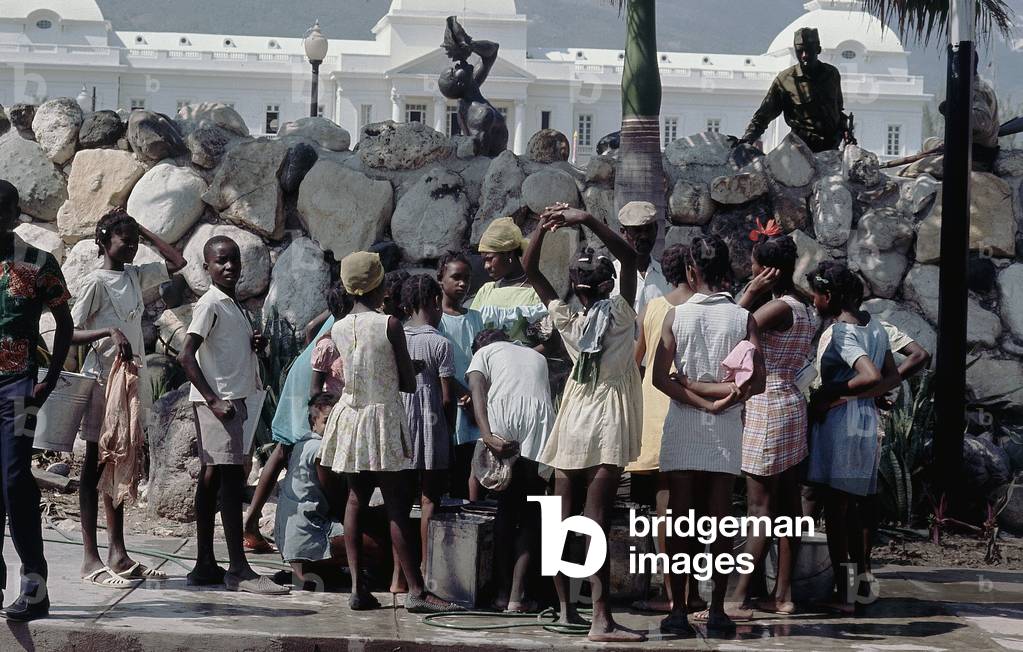 Girls in line at a fountain in the town of Port-au-Prince, Haiti (photo)