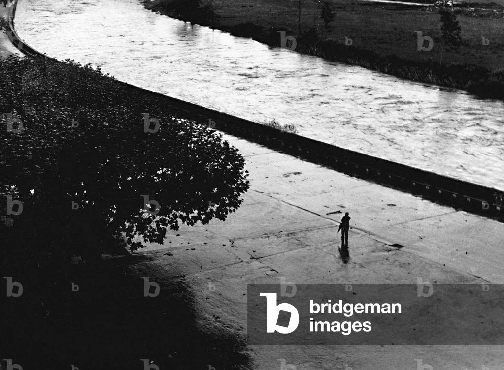 Man walking along the river Gave de Pau in Lourdes