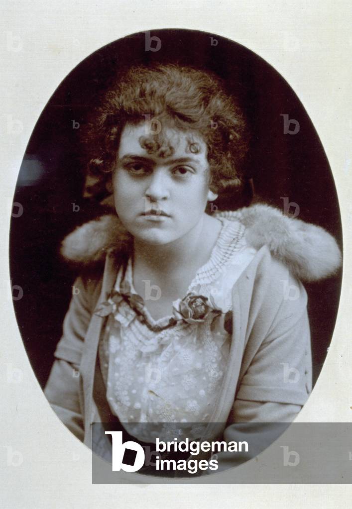 Portrait of a woman wearing a fur collar, a blouse with emproidery and an applied flower