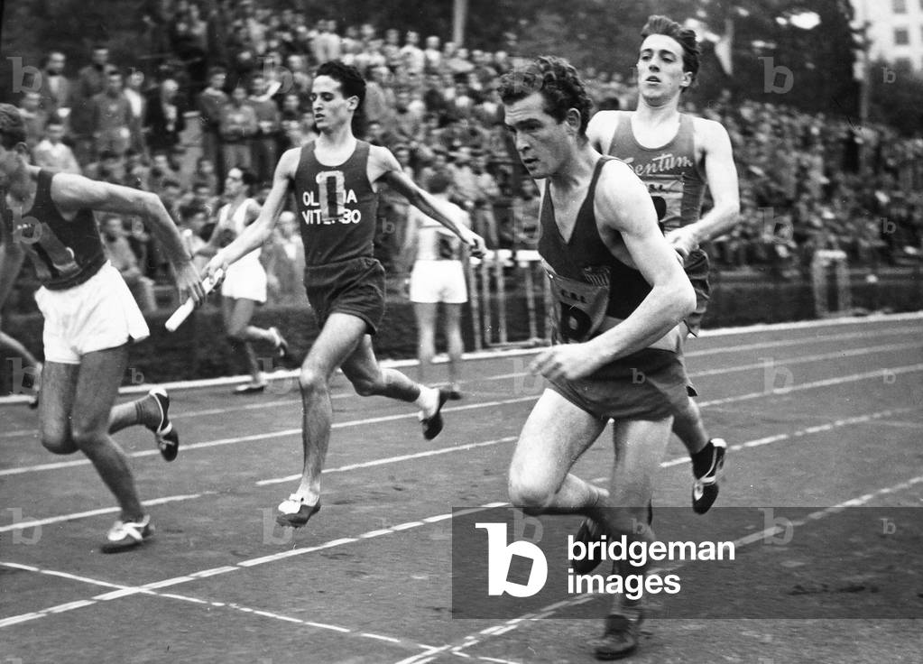 Runners passing off the baton during a relay race