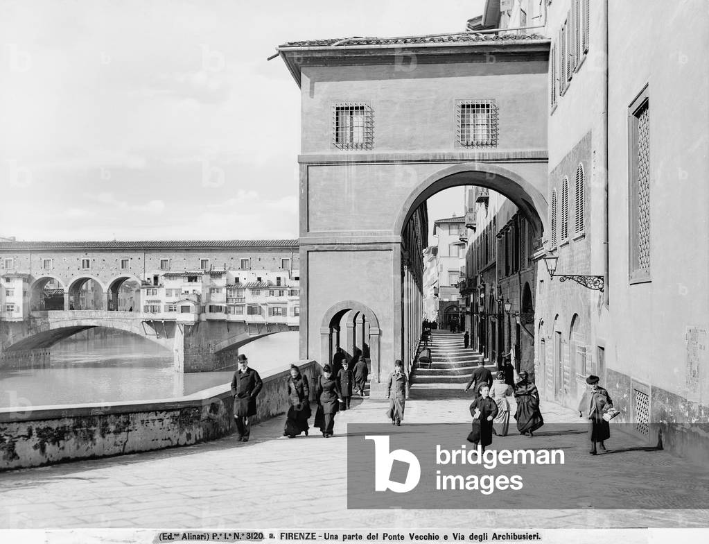 View with people of Lungarno degli Archibusieri and part of the Vasari Corridor. Ponte Vecchio is in the background