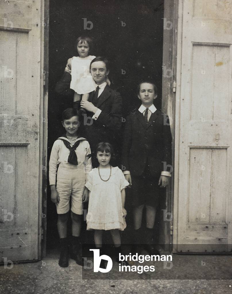 A group of children and boys photographed in front of a door