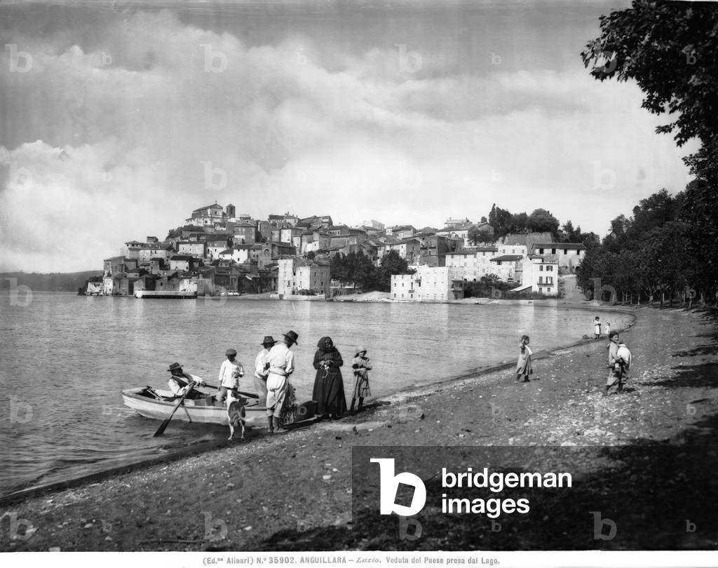 Group of people on the banks of Bracciano Lake, which faces the town of Anguillara Sabazia, near Rome, in Lazio