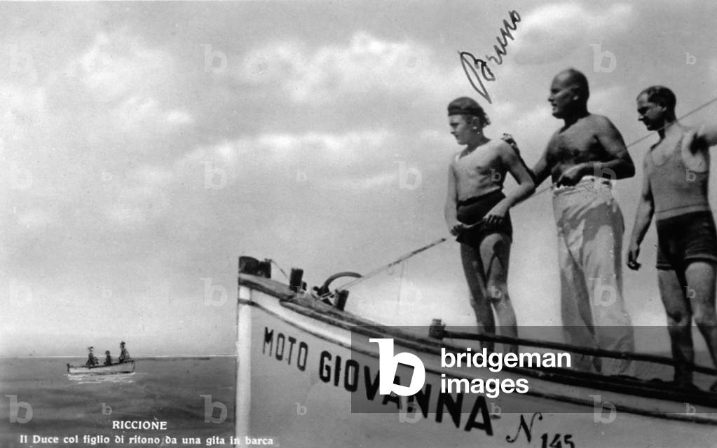 Mussolini shown with his son, returning from an outing in a boat (b/w photo)