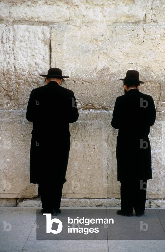 Jewish people praying in front of the Wailing Wall