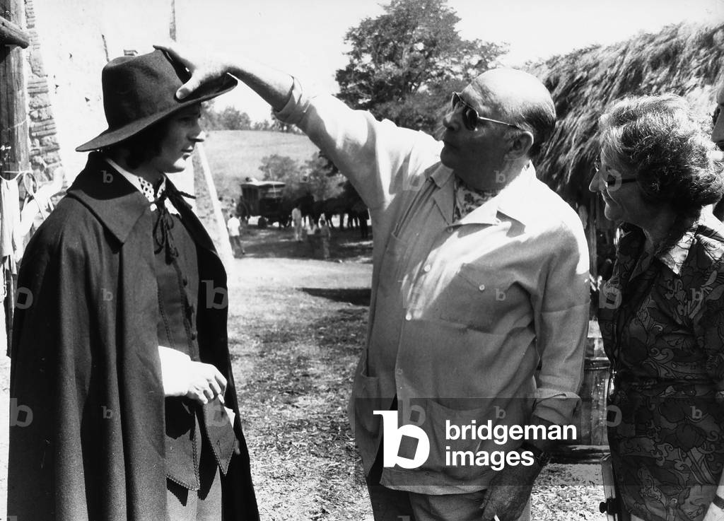 The director Roberto Rossellini while adjusting the hat of the actor Pierre Arditi, protagonist of his film, 