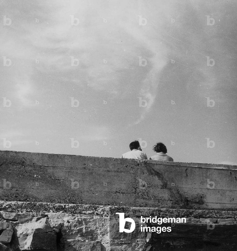 Couple sitting behind a wall