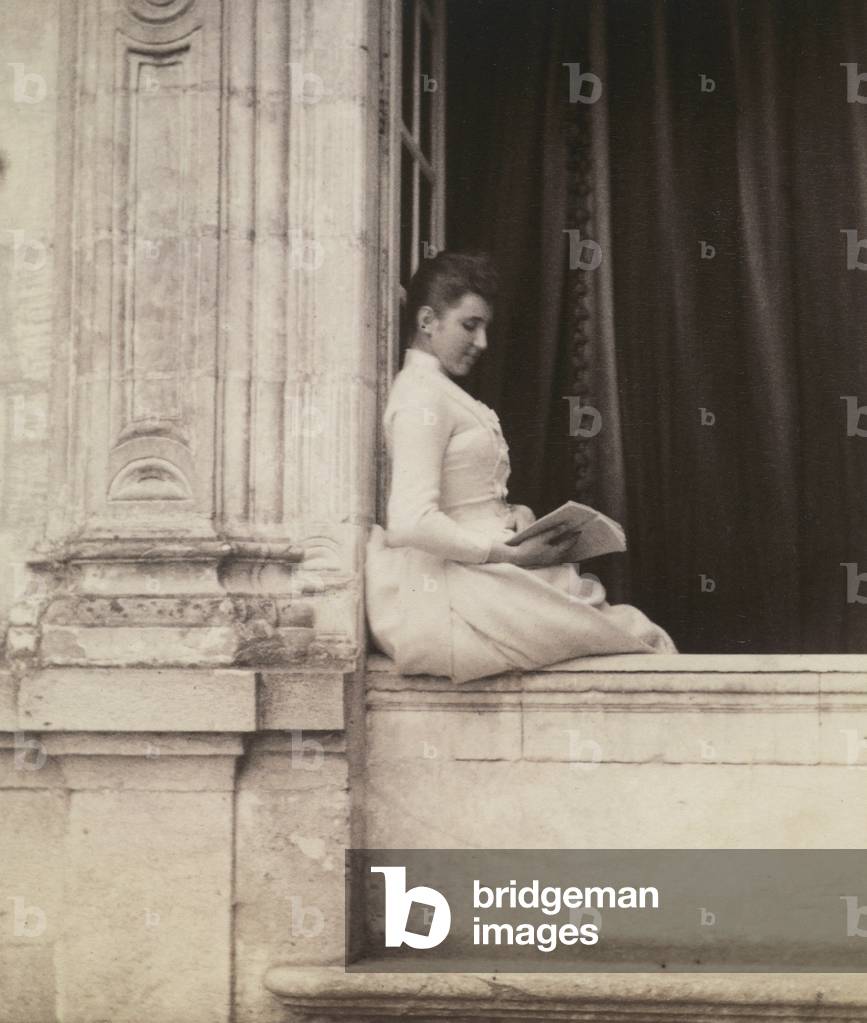 Mrs. Blanche Goldsmith posing on a window sill, while reading a book