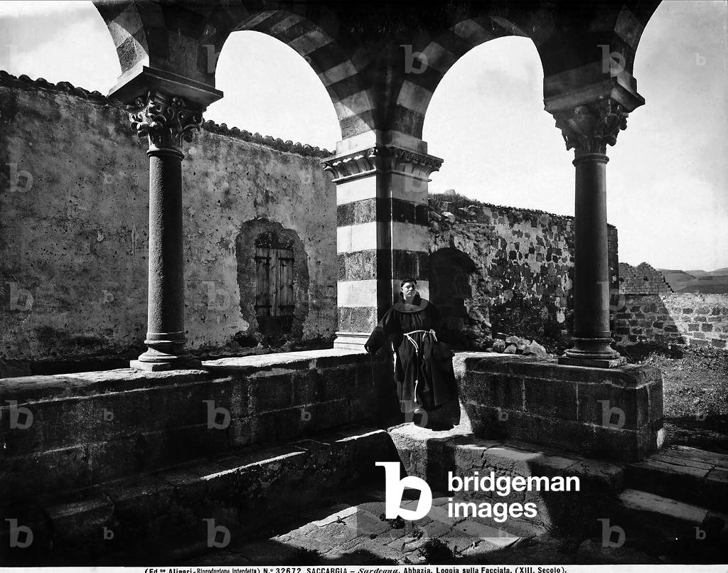 A friar on the portico of the church of the SS. Trinità in Saccargia, near Sassari, Sardinia