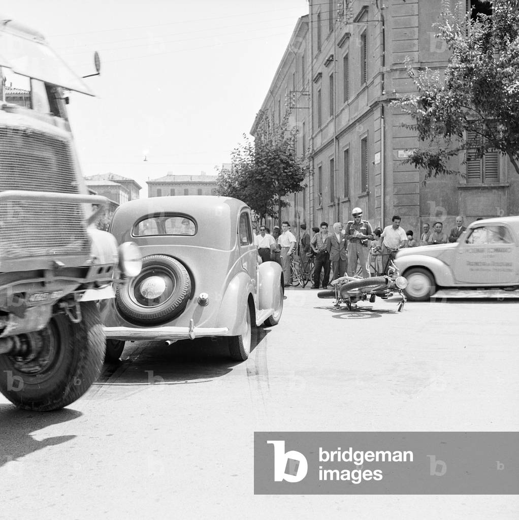Scene of an accident in the city: a car and a motorcycle involved (b/w photo)
