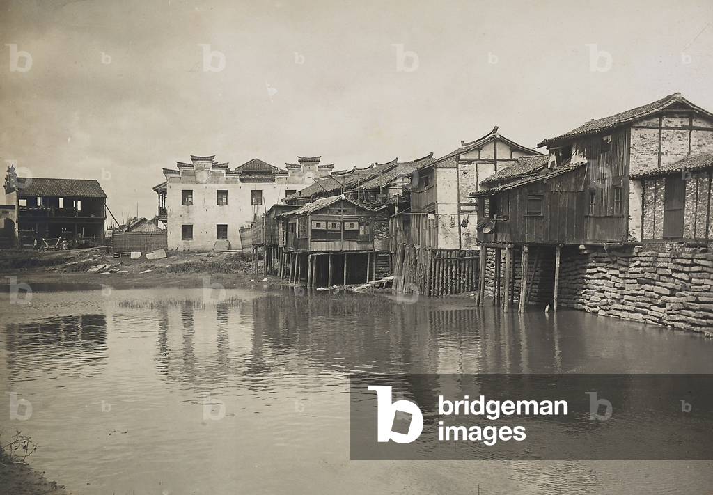 Houses and pilings located on the banks of a river in Japan