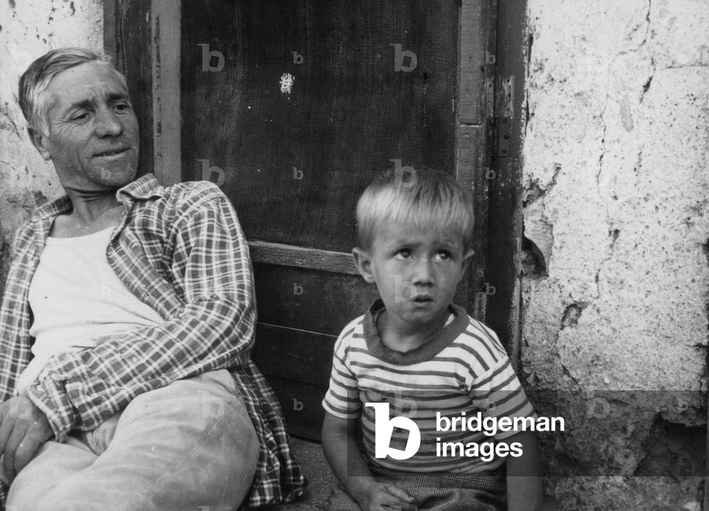 Man with child in the township Borghetto Latin in Rome (b/w photo)