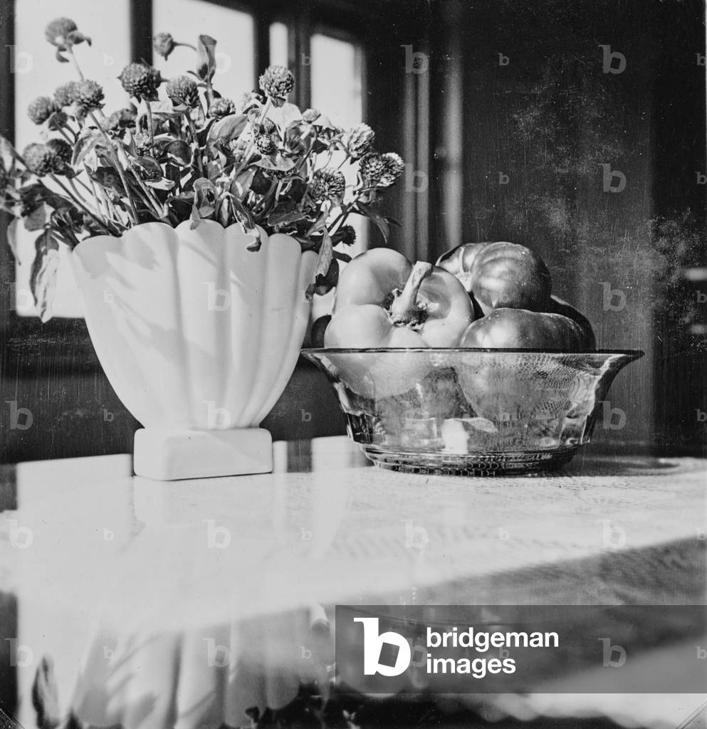 Vase of flowers and bowl with peppers