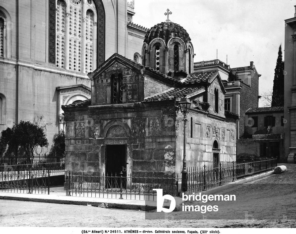 View of Athens with the façade of the old Byzantine church of Agii Theodori in the foreground.