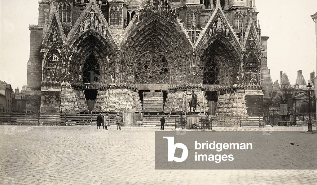 Front portals of the facade of the Reims Cathedral and the equestrian monument to Joan of Arc, work of P. Dubois. The entrances have been protected with barrieres contructed with sacks. The photo was taken during WWI (b/w photo)