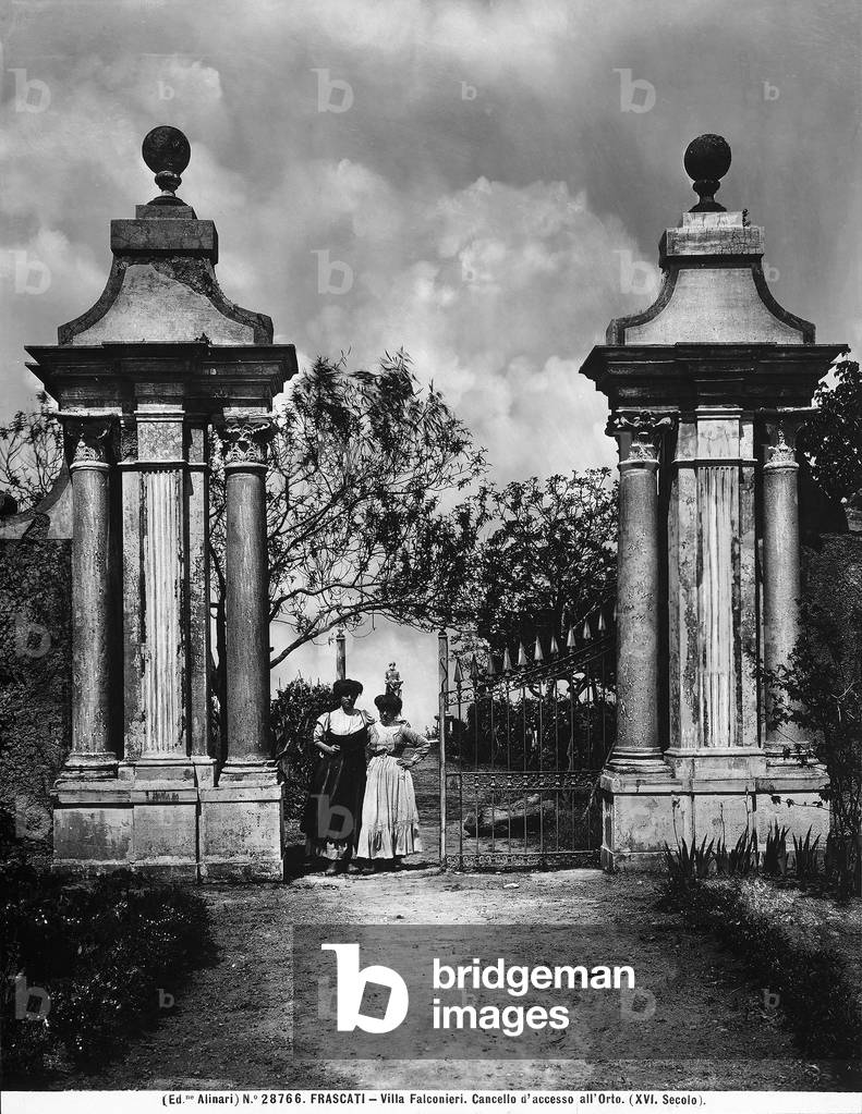 Two women standing near the entrance gate to the orchard of Villa Falconieri in Frascati, province of Rome