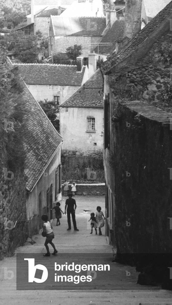 Children playing in the center of Semur (b/w photo)