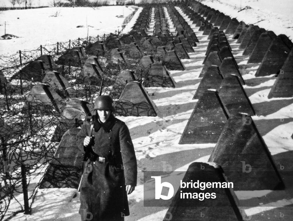 German soldier crosses reinforced concrete barrage (b/w photo)