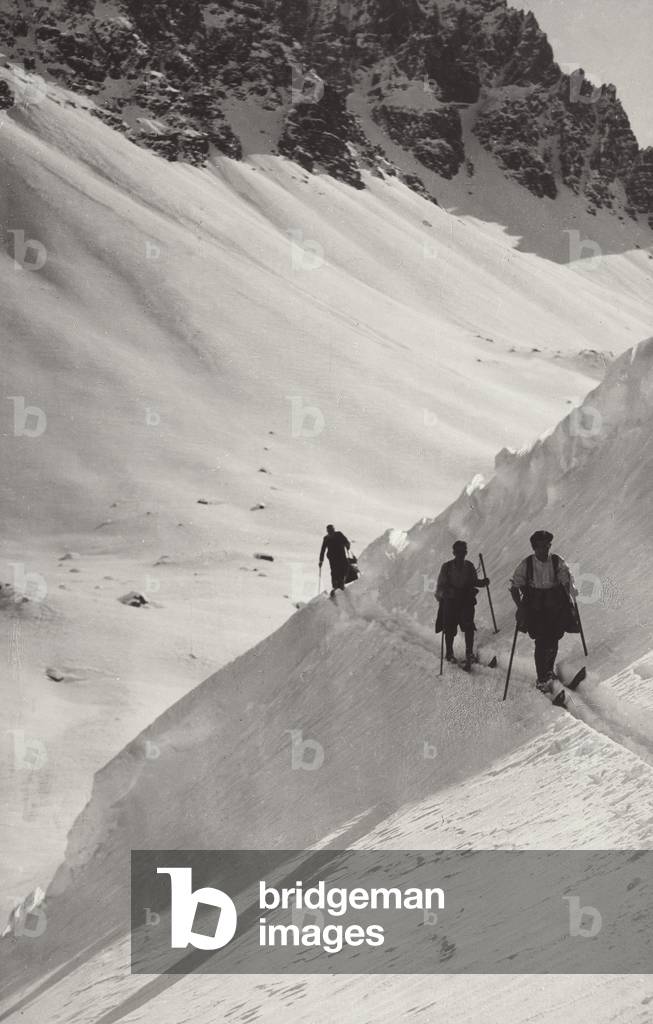 People with skis on a hill side covered by snow