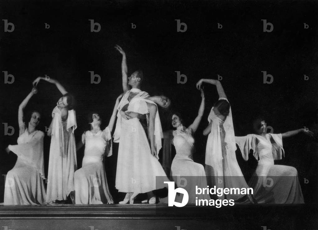 Ballerinas on stage execute coreographic figures during a ballet.