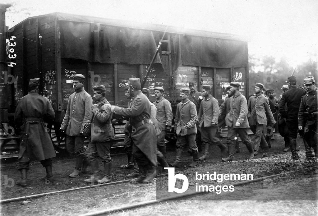 The image shows a German prisoners column in France, near to a train. (b/w photo)