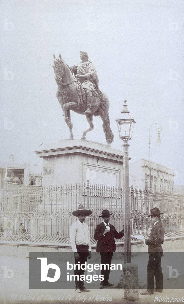 Three Mexicans, one of whom is wearing a large sombrero, under a street lamp next to the statue of Charles IV in Mexico City, 1890 (print on double-weight paper)