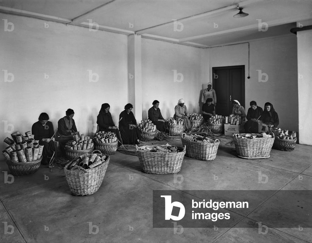 Women making straw bottles for maraschino liqueur at the Luxardo company of Zara.