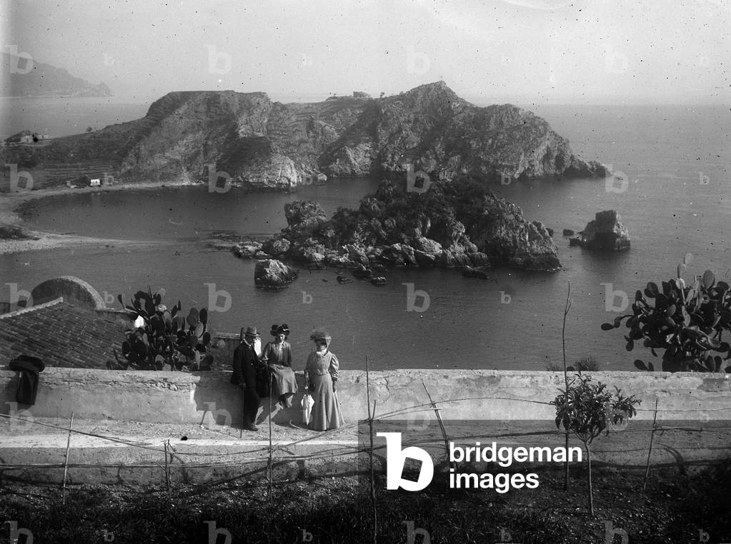 Group portrait in a garden of Taormina. In the background view of the coast and Isola Bella