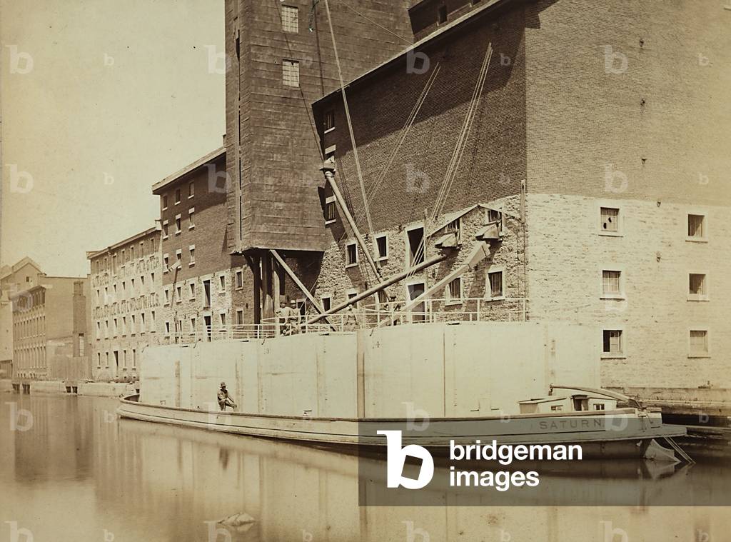 Barge loading materials from the holds on the Rhymney canal, in Great Britain