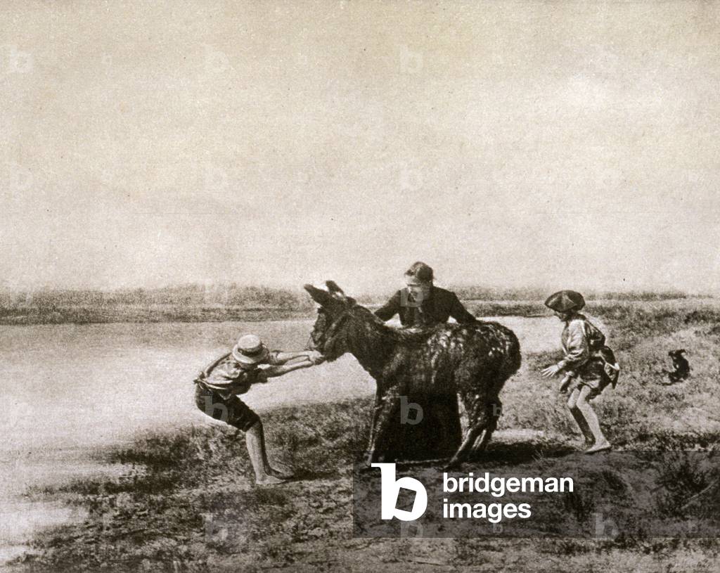 Artistic photograph by J. Mantelier of a scene in the country. At the center of the picture a stubborn donkey is being dragged by a boy and a woman towards a pool