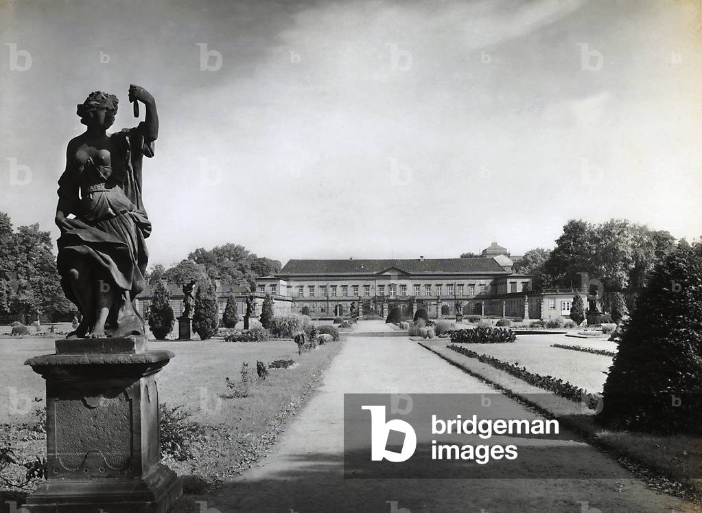 Façade and park of the Herrenhausen Castle, in Hannover. The castle was destroyed during WWII, today the frescoed double portico still remains standing. A baroque statue in the park is in the foreground
