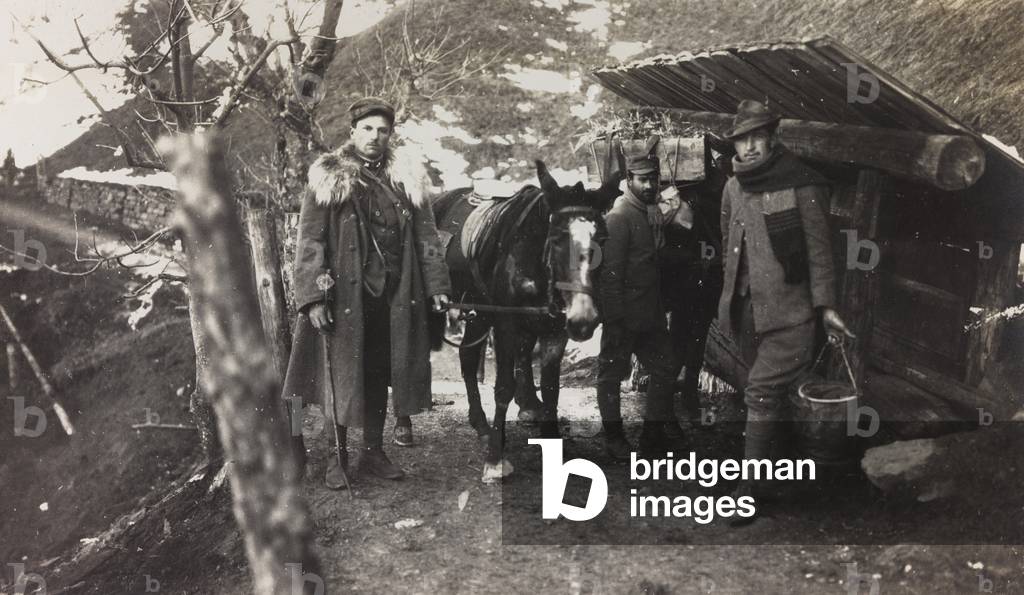 World War I: Italian soldiers with a donkey near a fountain on the Col di Lana (b/w photo)