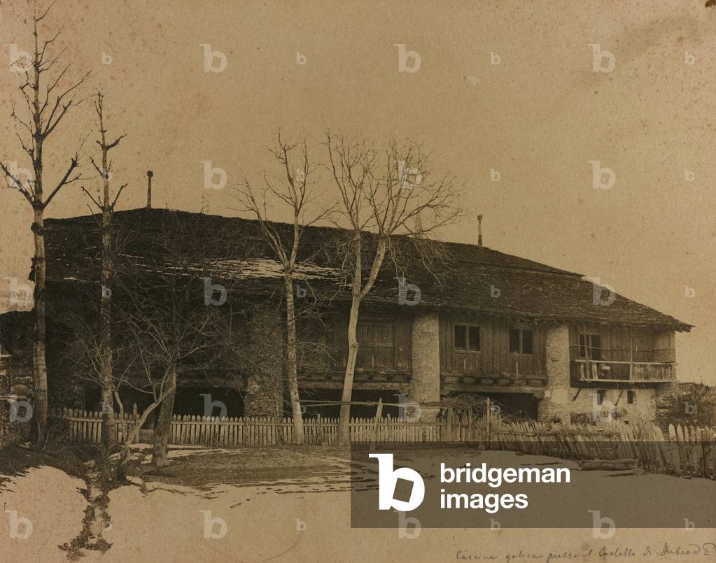 The southern side of the old Building known as 'L'Ola' (15th Cent.) Along the road that leads to the Castle of Introd, in the Valle d'Aosta. In front of the farm fouse, protected by a fence, is a field covered by a light layer of snow