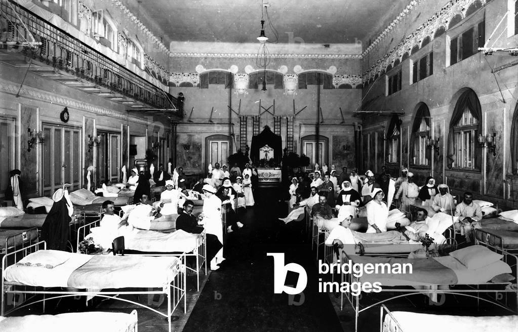 Decorated salon at a hospital with war wounded and Red Cross nurses (b/w photo)