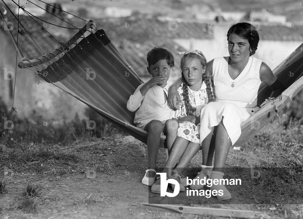 Portrait of a woman with two children in a hammock