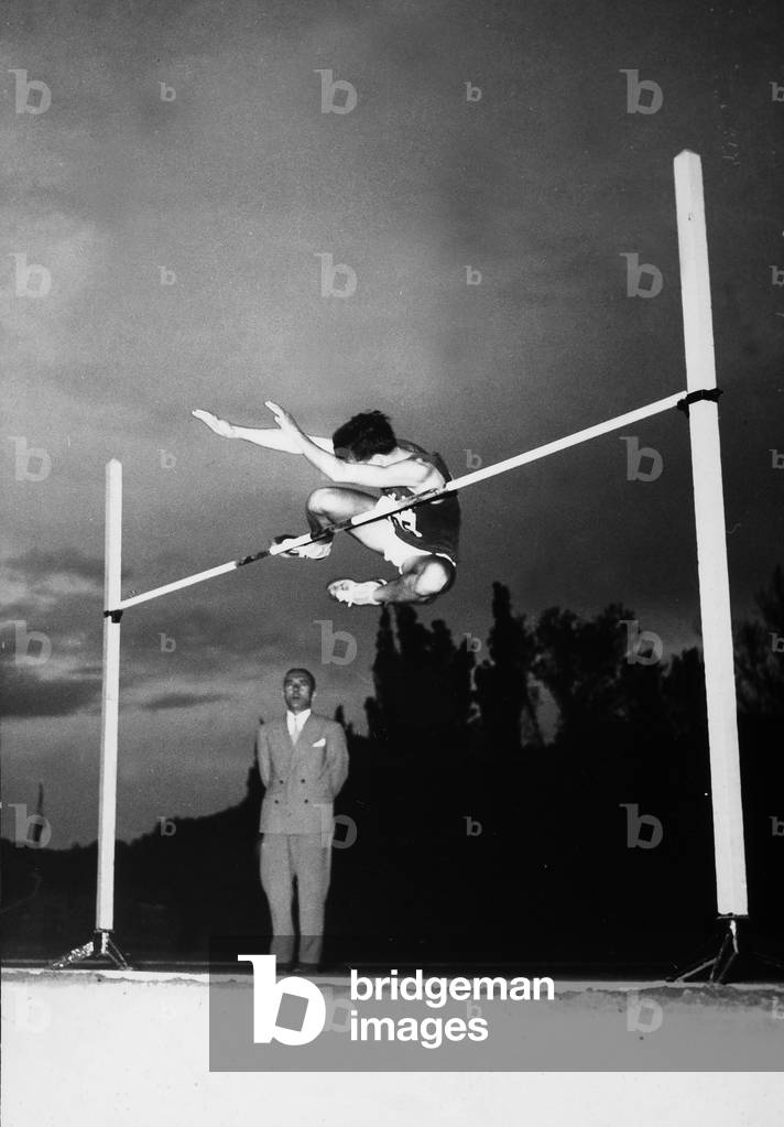 The ceremonies and games called by the Centro Sportivo Italiano: an athlete doing the high jump before the judge of the competition