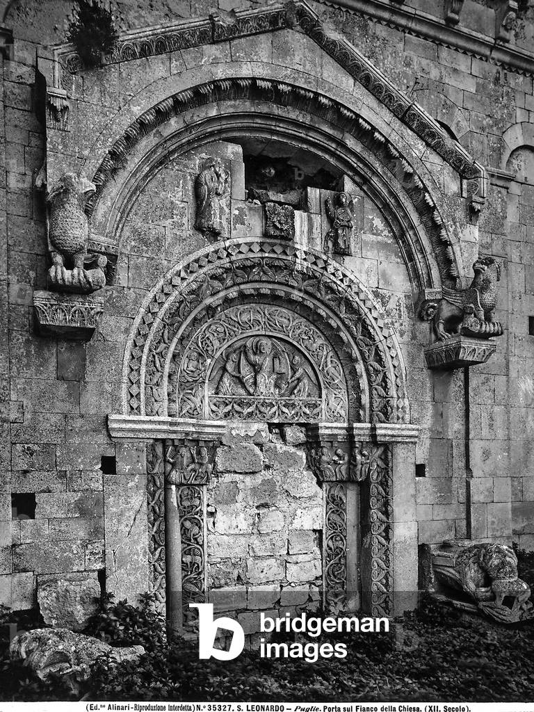 Detail of the portal of the Church of S. Leonardo di Siponto, Apulia. The work is adorned with various sculptures and is framed by a niche in the form of a canopy resting on two griffons. The jambs and the frames are decorated wih vegetal and zoomorphic ornaments. In the bas-relief lunette is Christ in almond held by two angels.