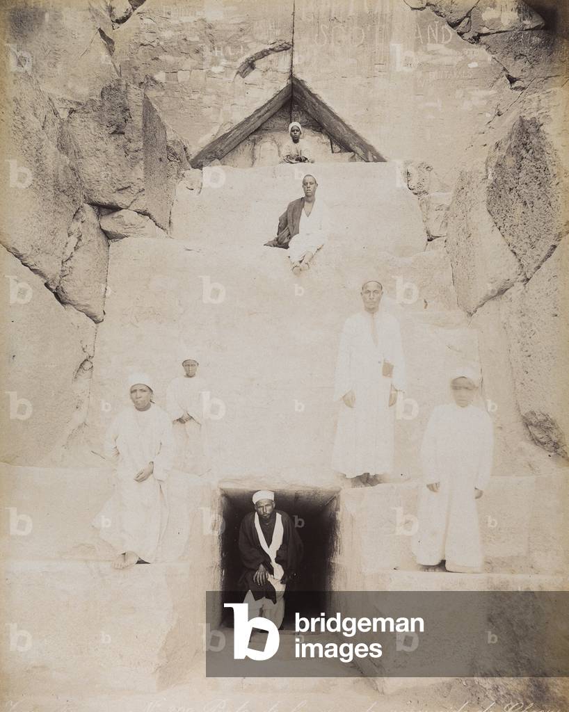 View of a group of Egyptians in traditional dress at the entrance of the Great Pyramid of Cheops. Cairo, El Giza, 1885 (print on double-weight paper)