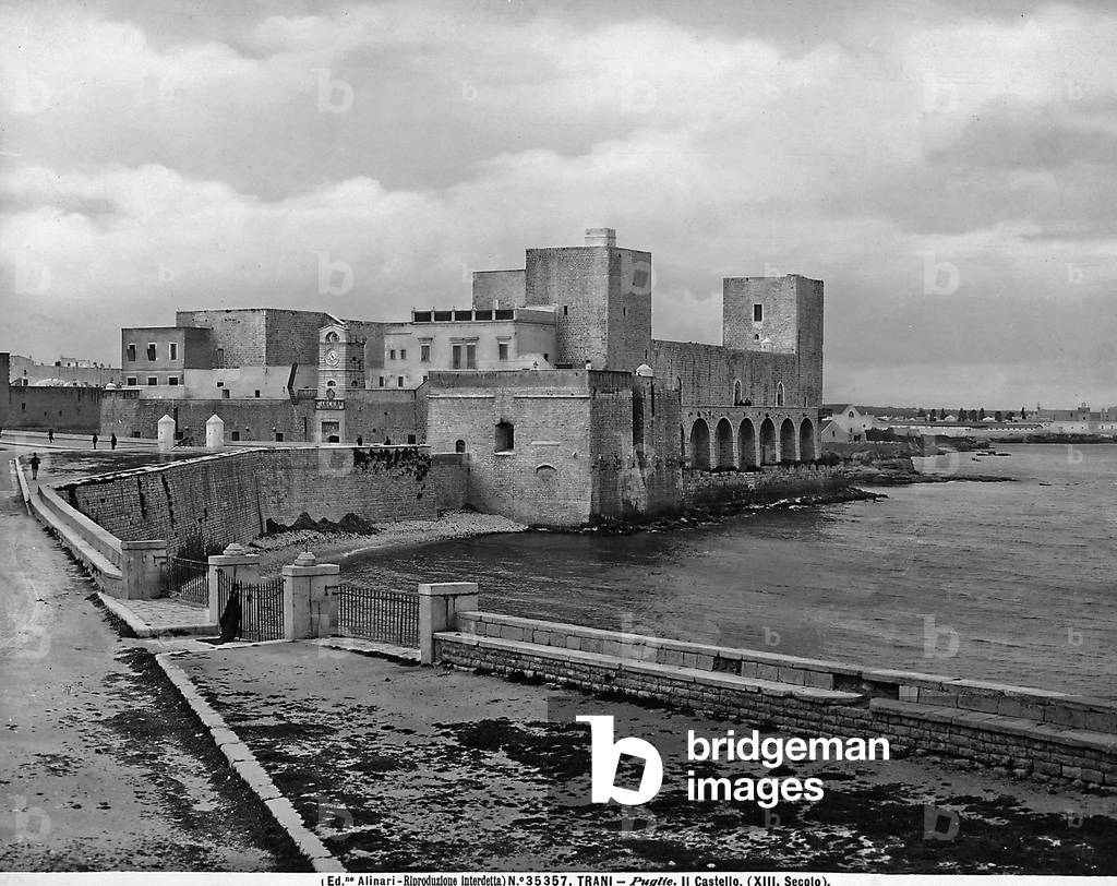 View of Trani Castle in Puglia. The part along the sea is visible with passersby.