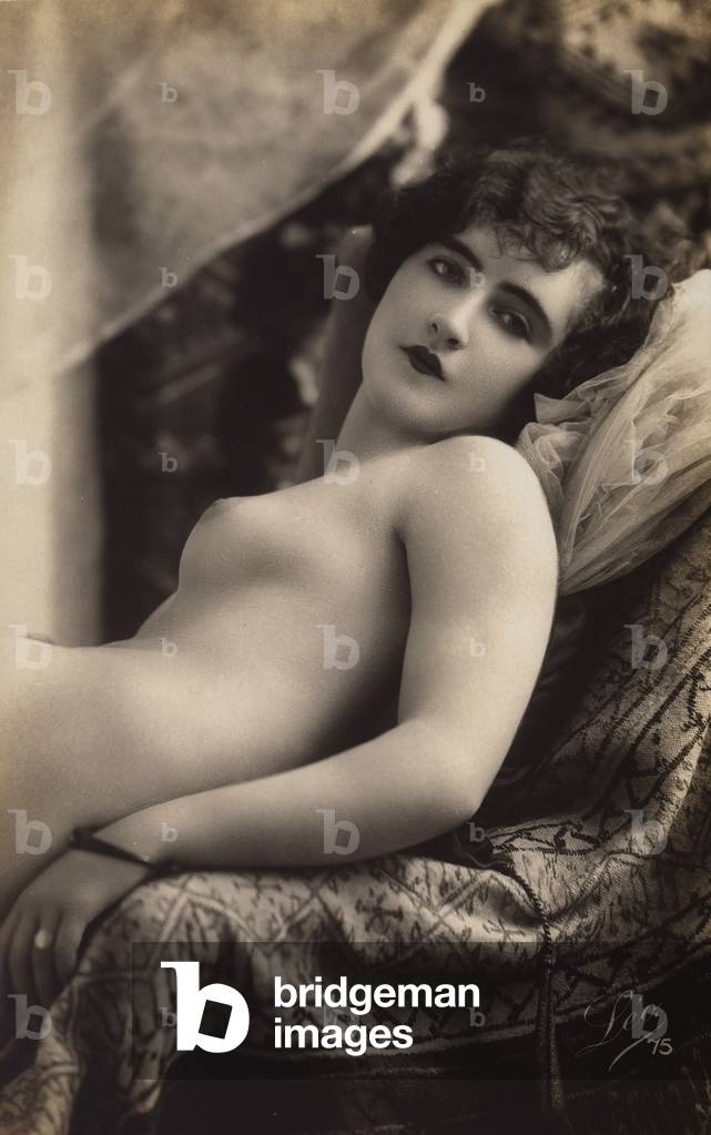 A young woman posing nude on a couch