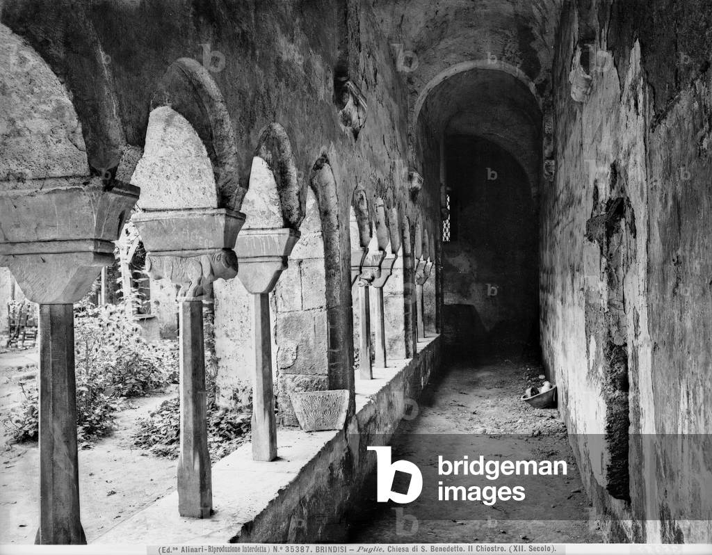 Partial view of the Cloister of the church of S. Benedetto in Brindisi. A portico is visible with polygonal columns and supported capitals some of which are decorated.