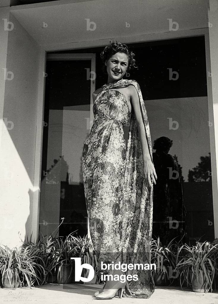 Model wears a long dress with a floral pattern created by the couture house 