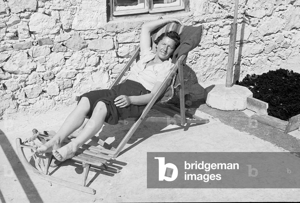 Woman sunbathing on a lounger in mountain, Cortina d'Ampezzo