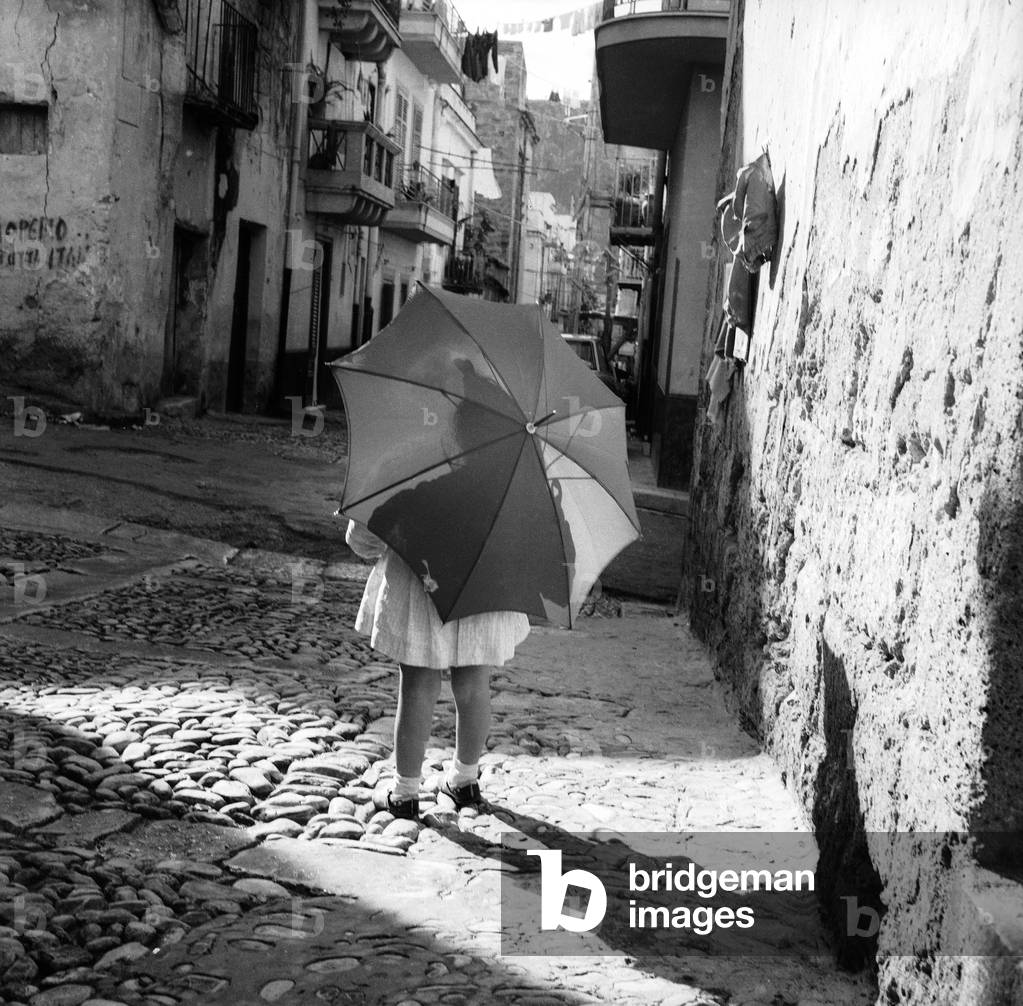 Portrait of a little girl with an umbrella on pavement, Sicily, 1967 (gelatin silver print)
